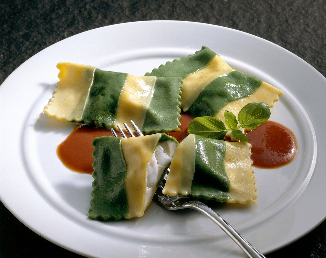 Teigwaren. Maultaschen mit grünen Streifen und Tomatensauce