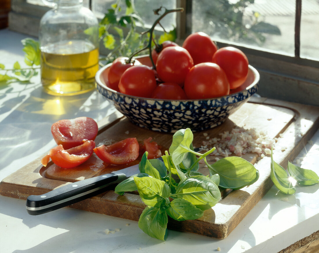 Nudeln aus aller Welt, frische Tomaten, Basilikum auf Schneidebrett