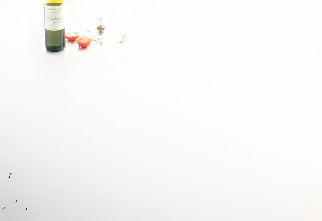 Bottle of wine, halved tomato and spice on white background
