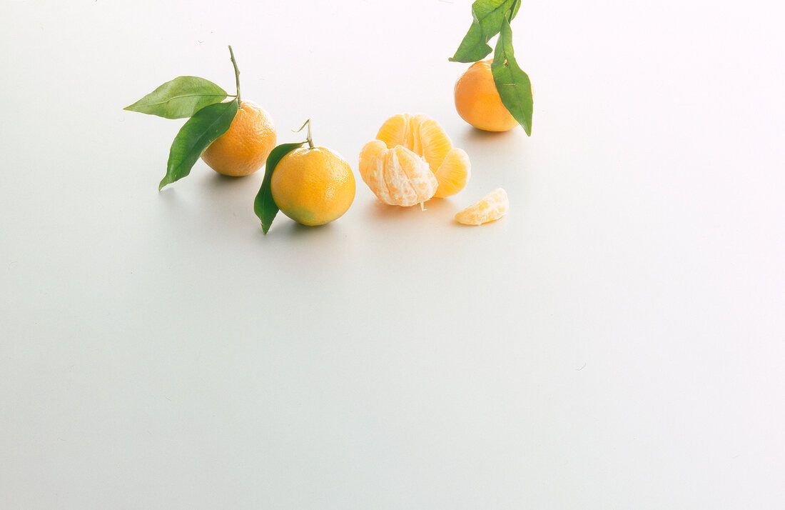 Mandarins with and without skin on white background