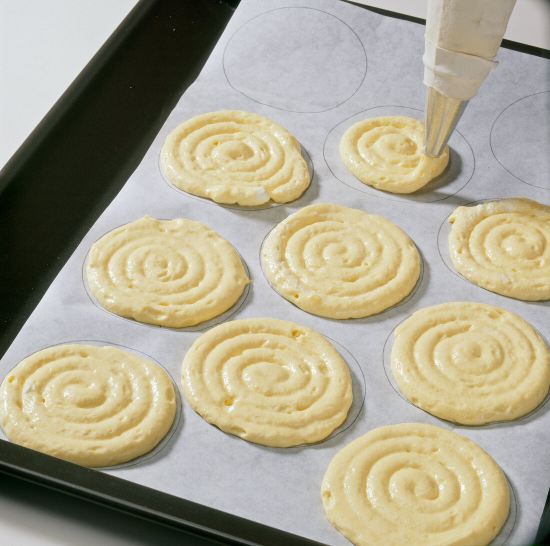 Circles being made with piping bag on baking sheet