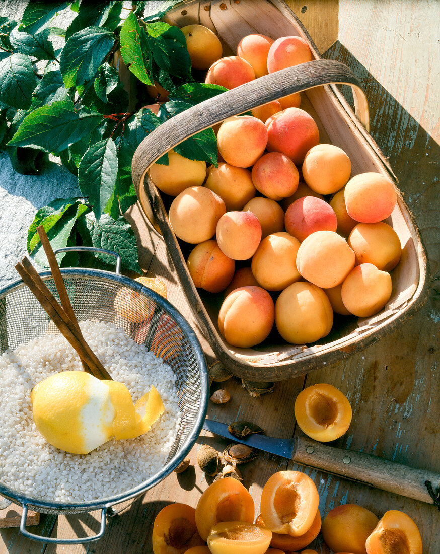 Apricots in basket and rice with lemon on it in sieve, elevated view