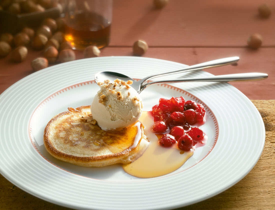 Pancakes with maple syrup and hazelnut ice cream on plate