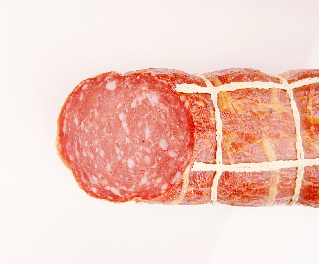 Close-up of old German ham sausage on white background