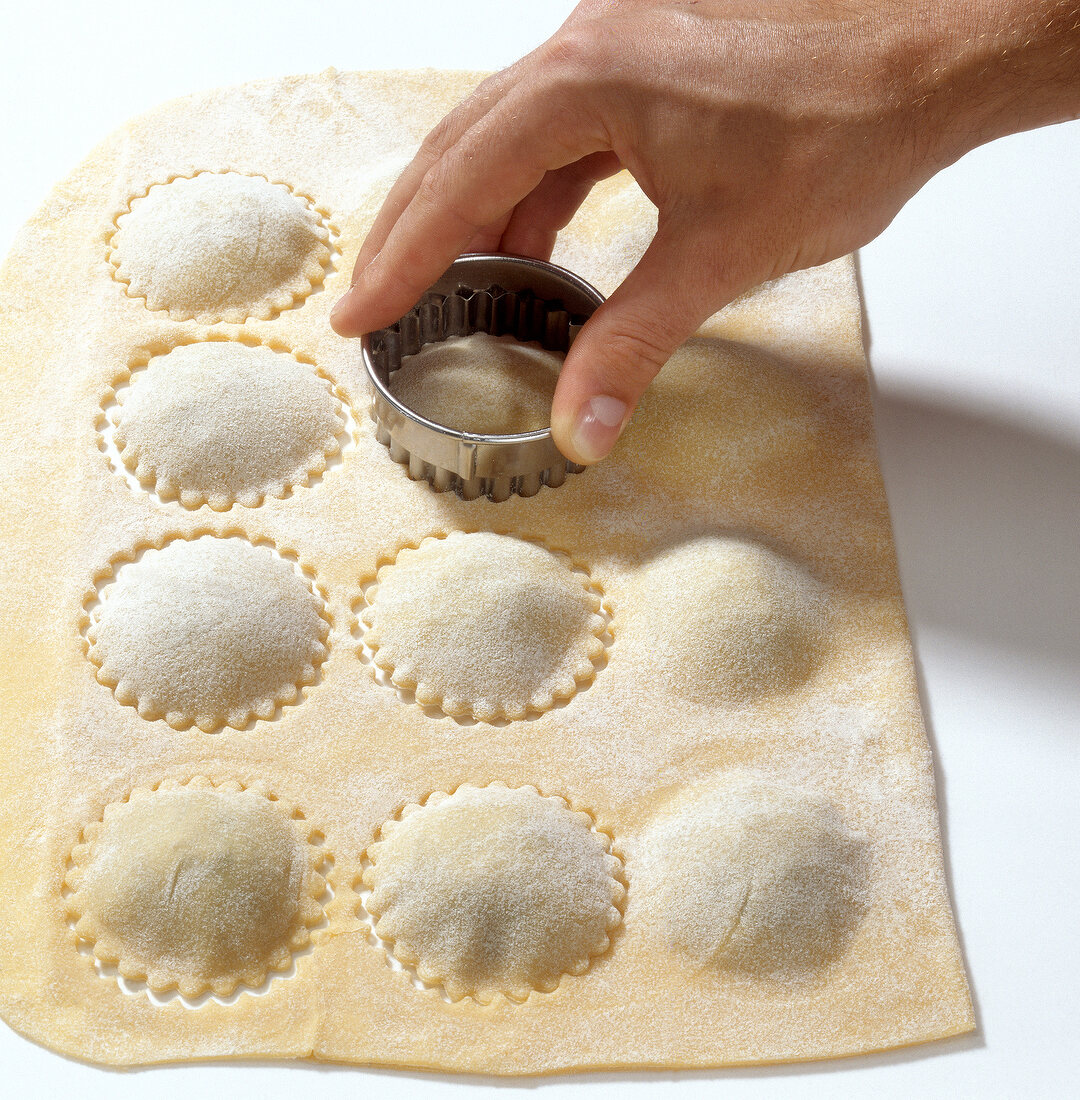 Stuffed dough sheet being cut with cookie cutter while preparing braised oxtail, step 7