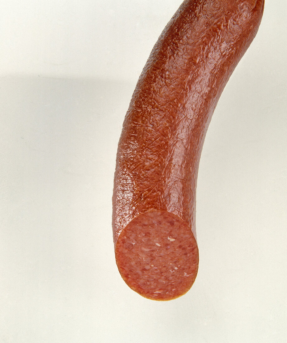 Close-up of rustic lamb salami on white background