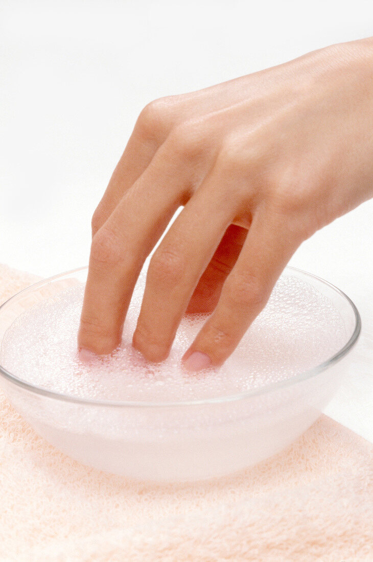 Close-up of woman dipping her fingers in soap water