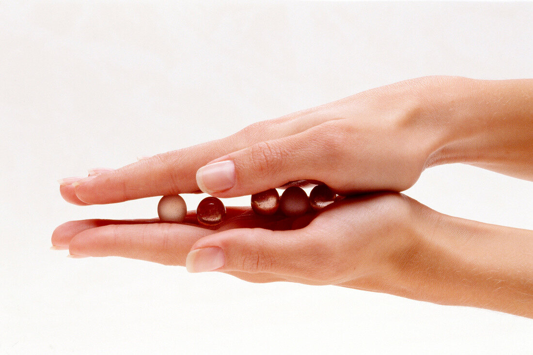 Close-up of woman rolling glass balls between her palms