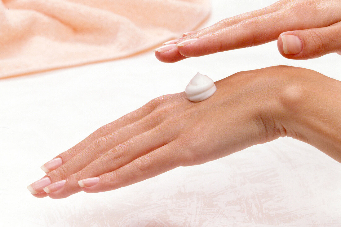 Close-up of woman applying moisturizer on her hand