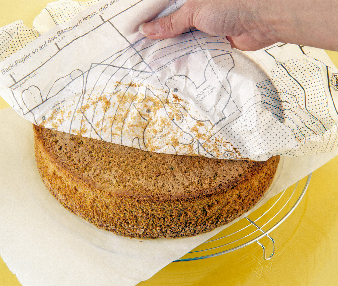 Baking paper removed from sponge cake on cake rack