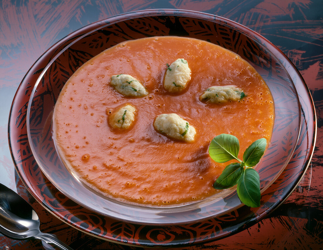 Close-up of cream of tomato soup with cheese and basil dumplings