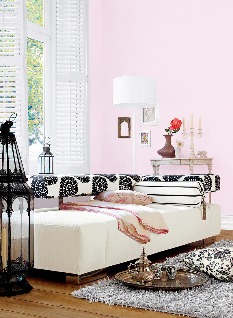 Living room with pink wall, sofa and big iron lantern