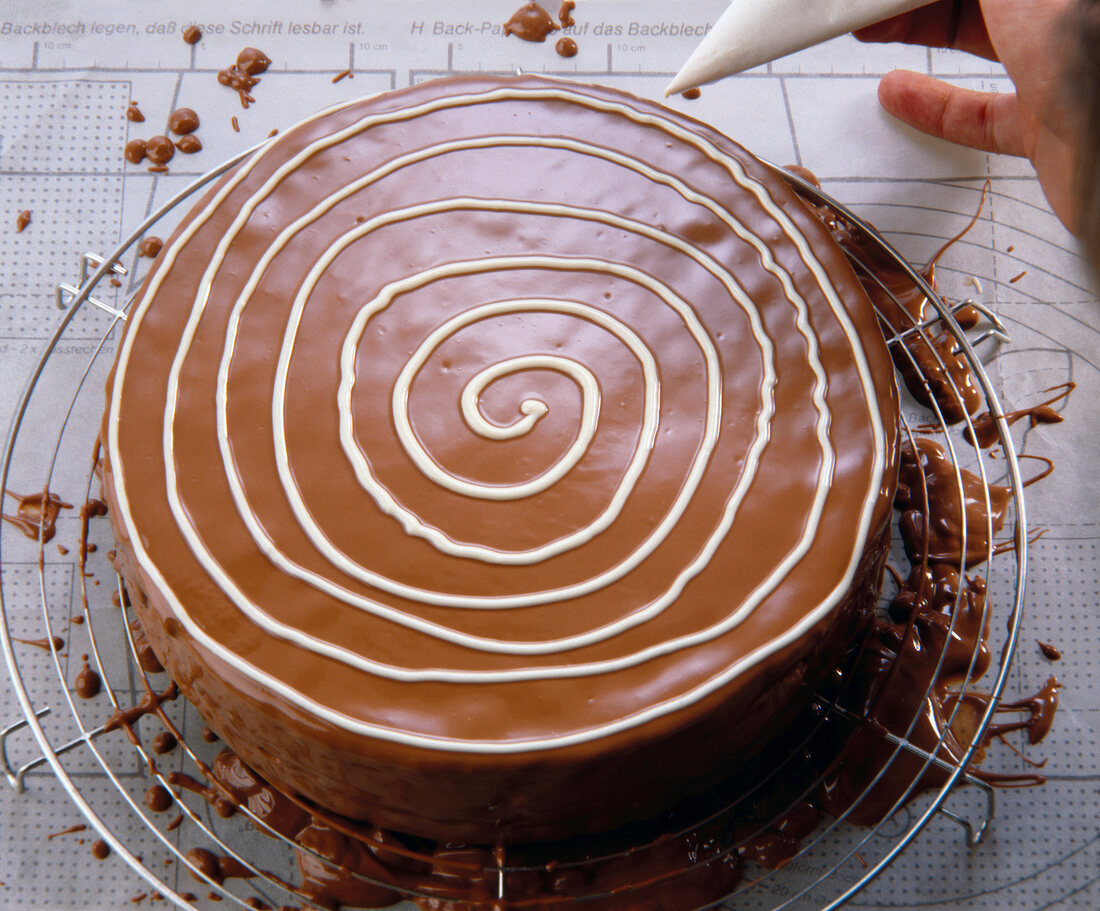 Decorating spirally with white chocolate on cake