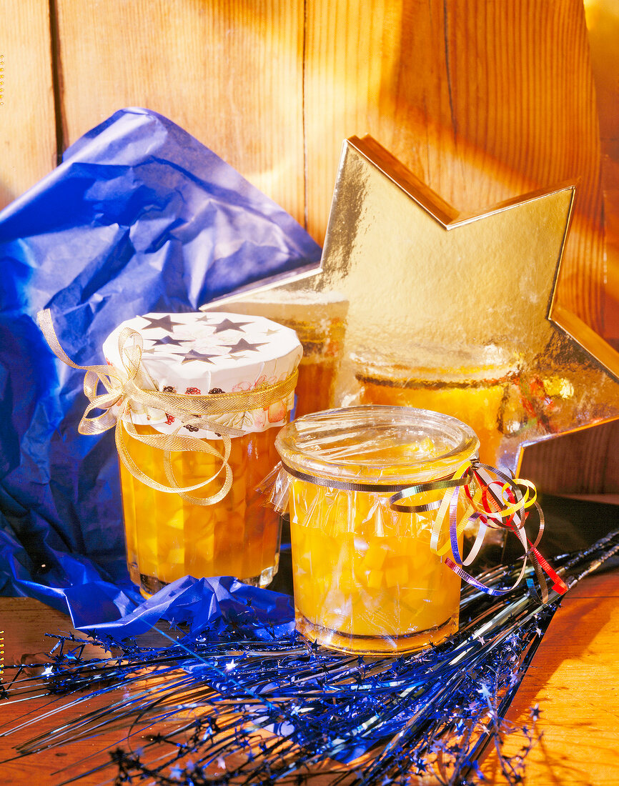 Gift wrapped glasses of orange and mango jam