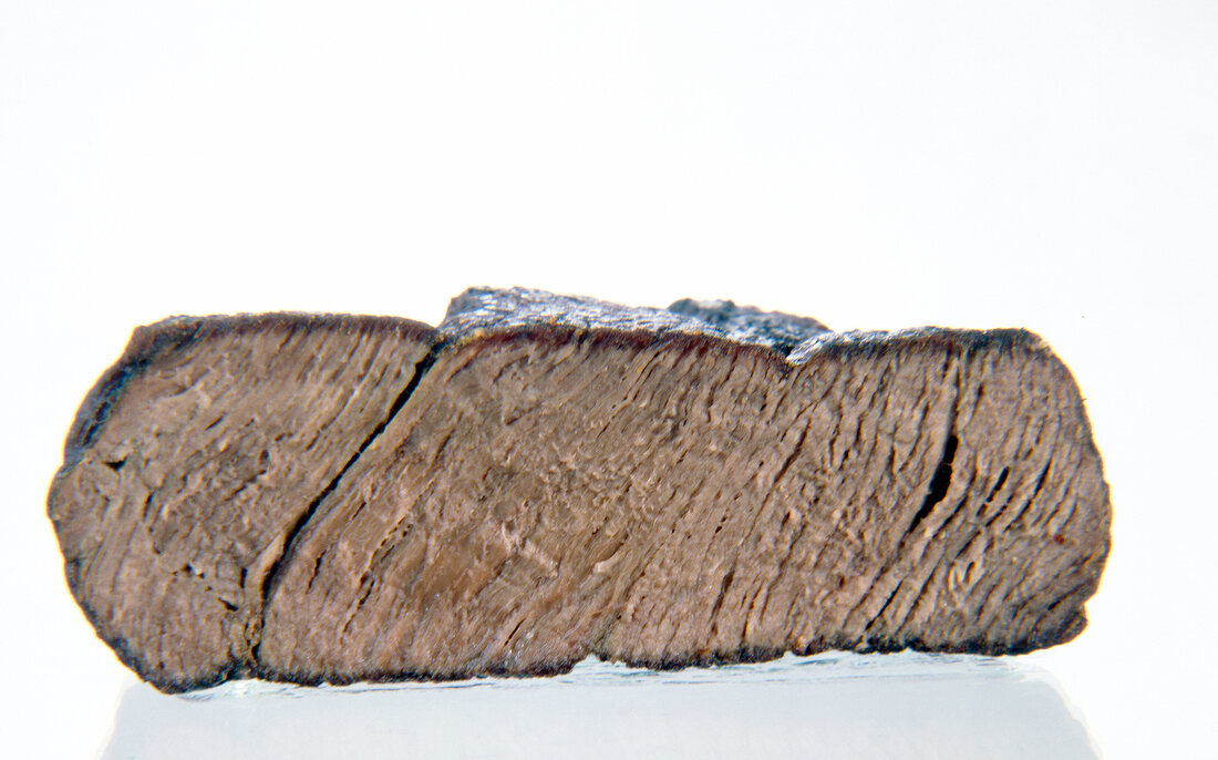 Close-up of well cooked steak fillet on white background