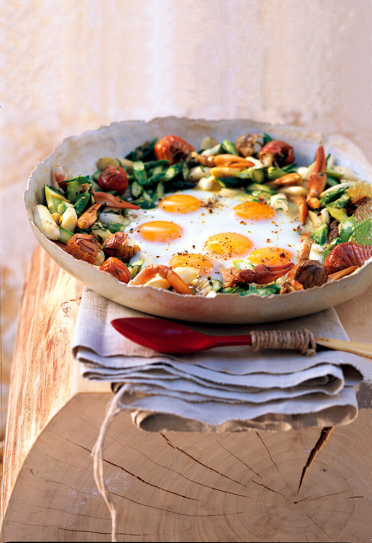 Fried eggs with asparagus and vegetables in bowl
