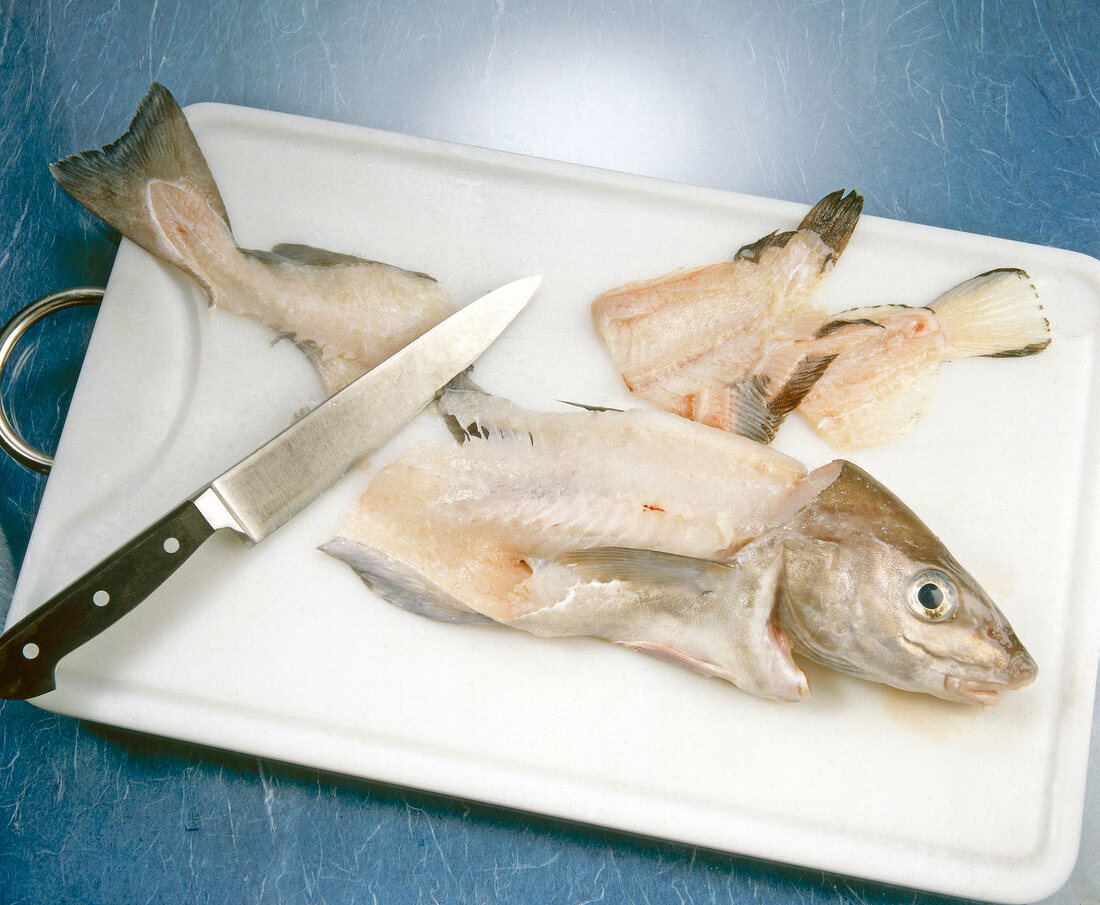 Pieces of fish on tray with knife