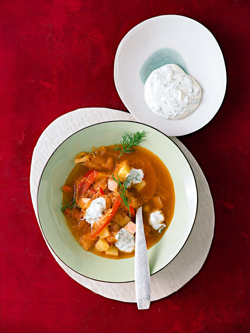 Sauerkraut and pepper soup in bowl with spoon