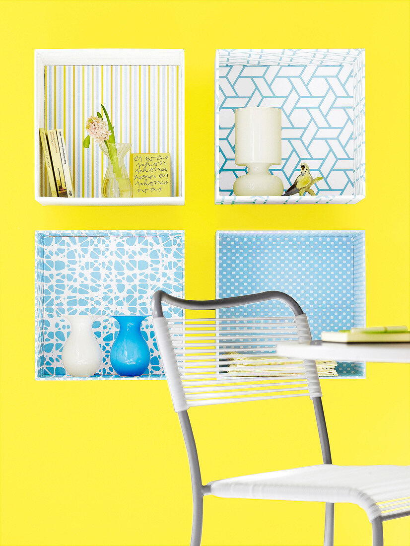 Yellow wall with shelves covered with decorative wallpaper