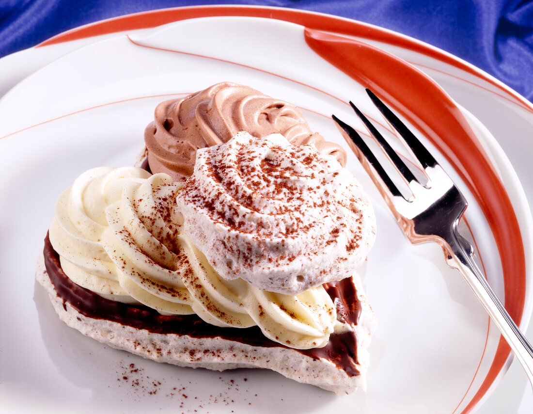 Heart shaped meringue with chocolate cream on plate