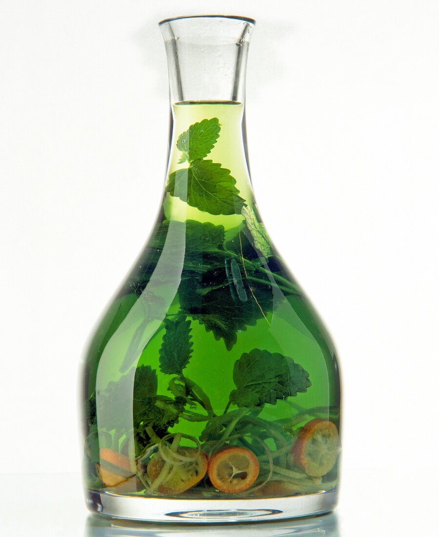 Green oil with citrus and grape-seed in flask