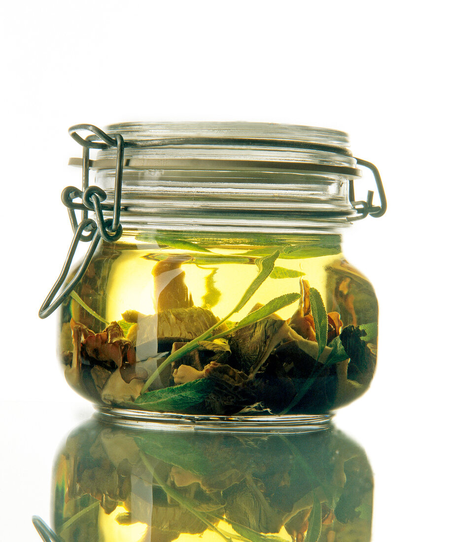 Yellow oil with fungus and sage in jar