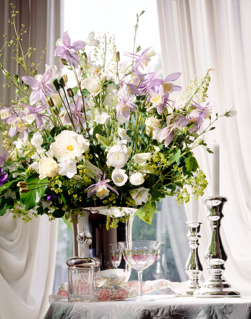 Flowers in champagne bucket on table