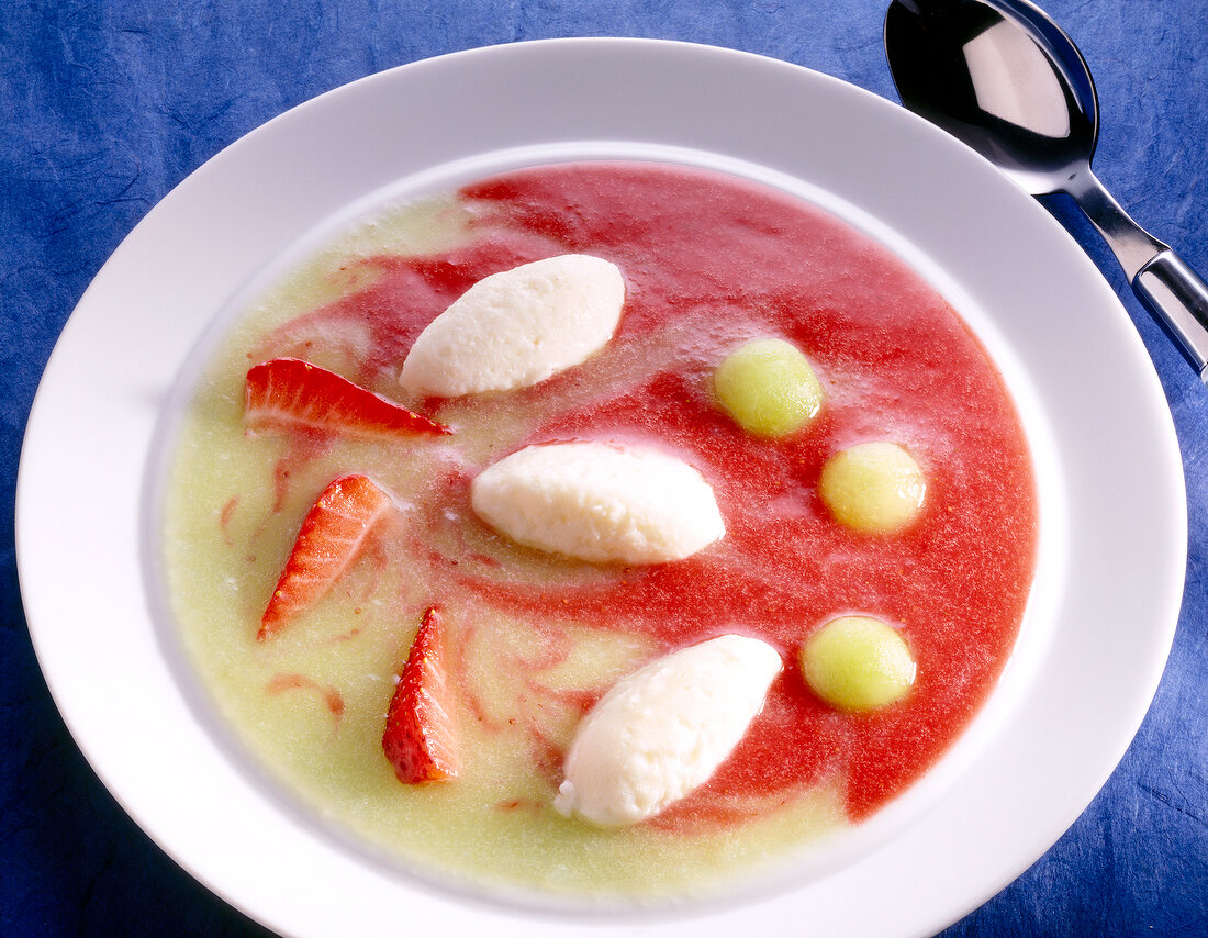 Close-up of cold fruit soup with quark dumplings in bowl
