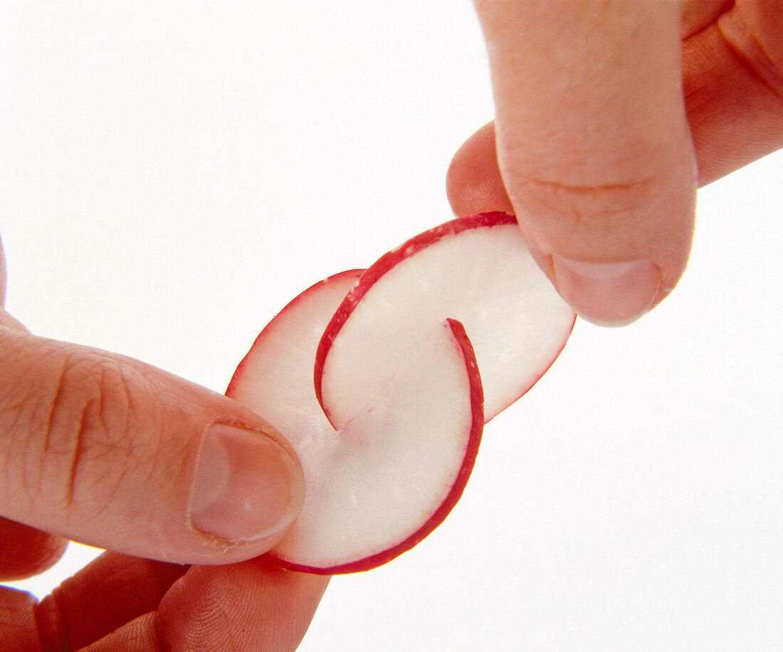 Radishes being put in one another against white background