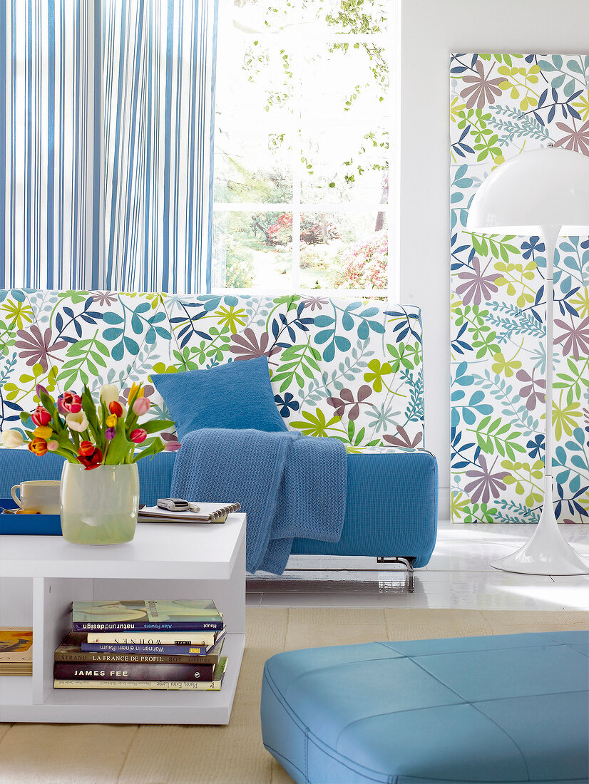 Living room with sofa, floral pattern fabrics on wall and striped curtains