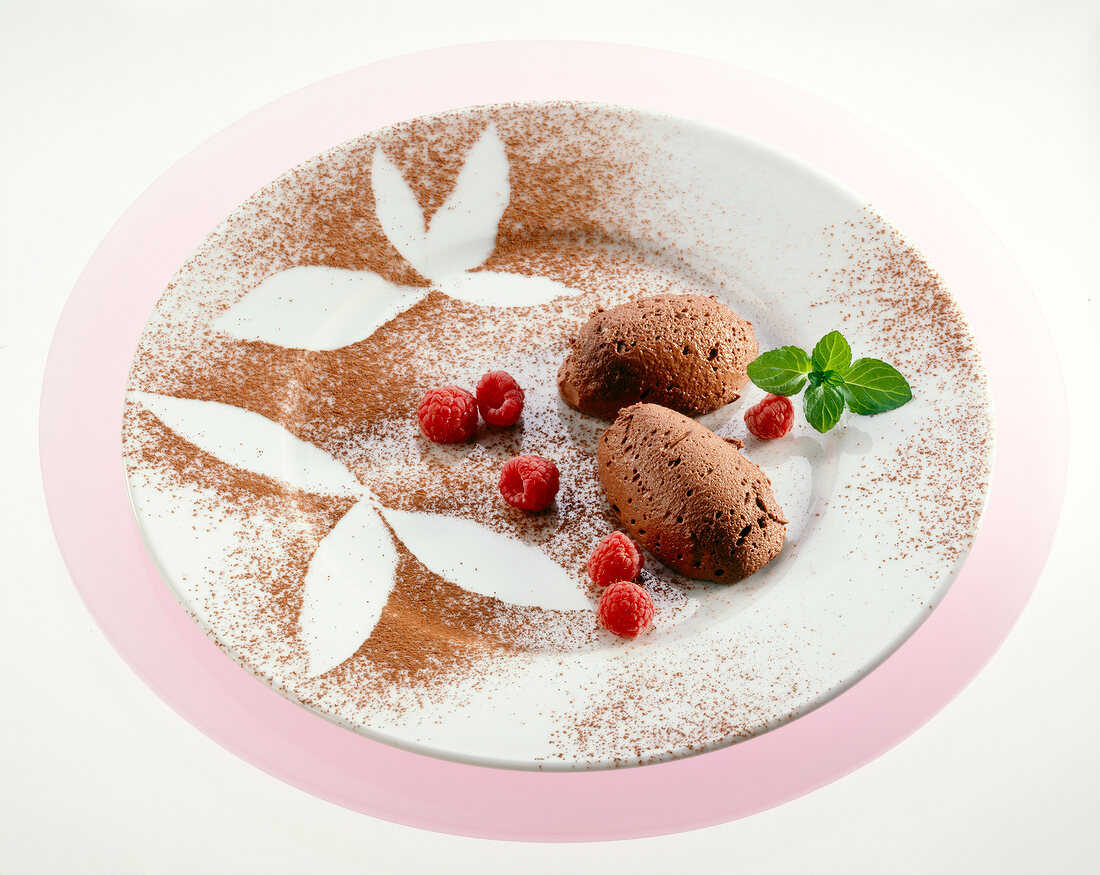 Chocolate mousse with strawberries and cocoa powder sprinkles on plate in leaf shape