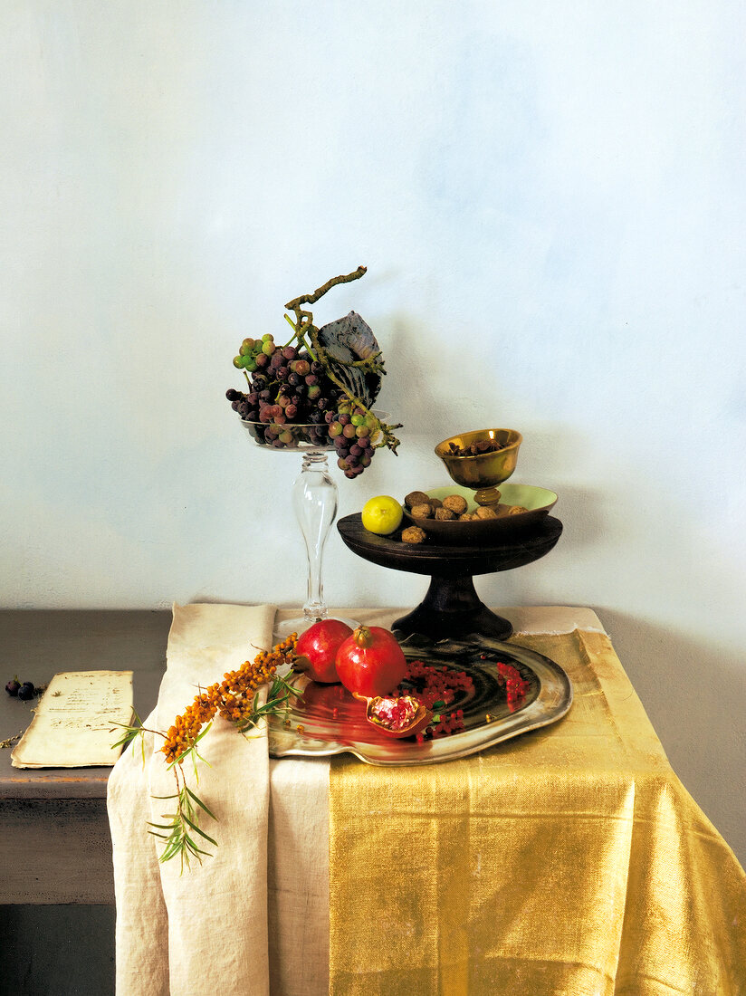 Wooden table with golden table cloth and fruits in bowl