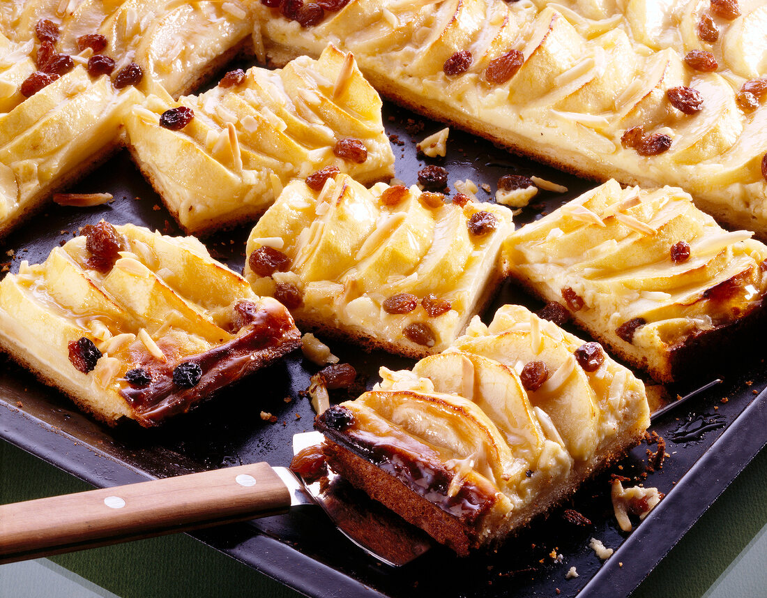 Apple cake with almonds and raisins on spatula