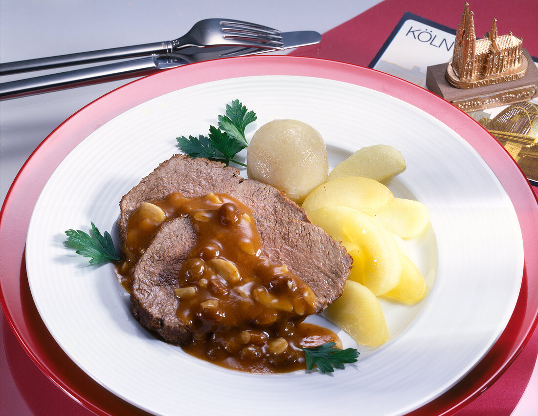 Sauerbraten with potatoes and coriander on plate