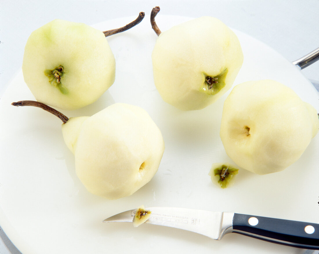 Washed and peeled pears with a kitchen knife