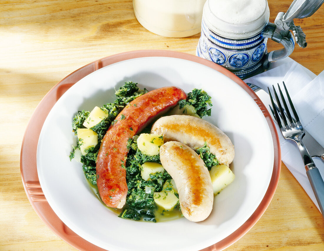 Kale stew with golden brown sausages on plate