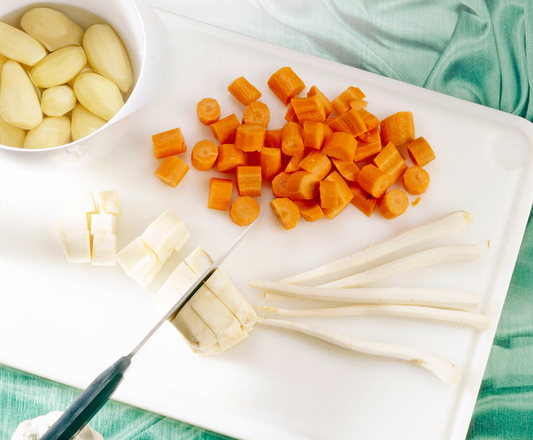 Chopped carrots and parsley root on chopping board