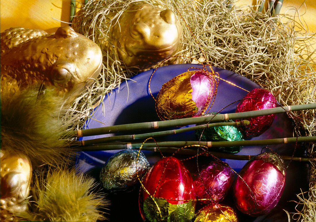 Easter eggs in colourful foil on plate - Easter decorations