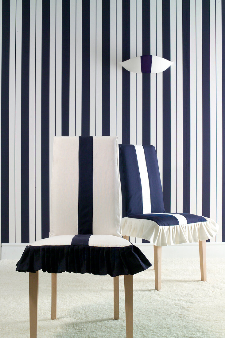 Two chairs with cover against black and white striped wall