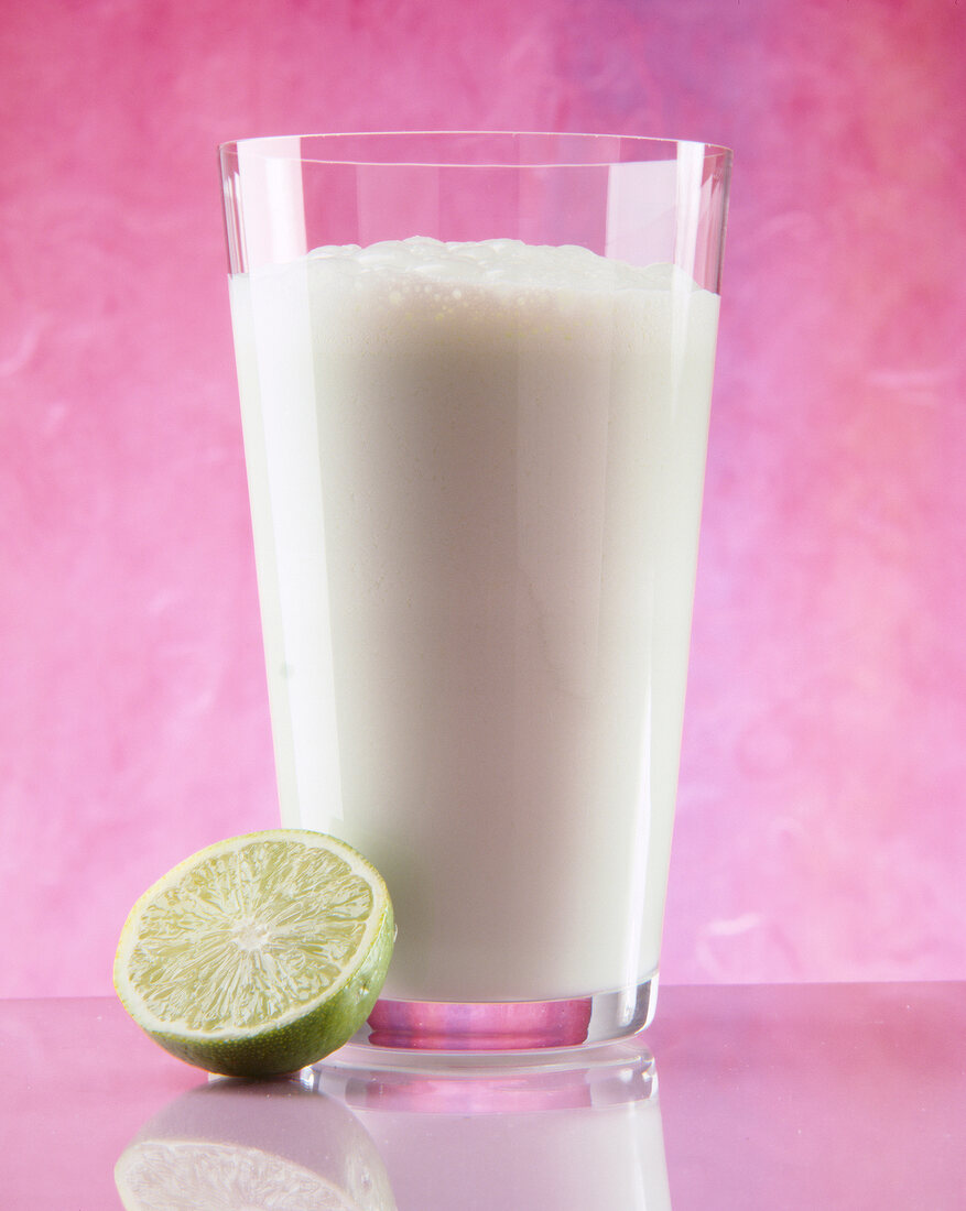 Melonen-Limetten-Drink mit einer Limettenhälfte neben dem Glas