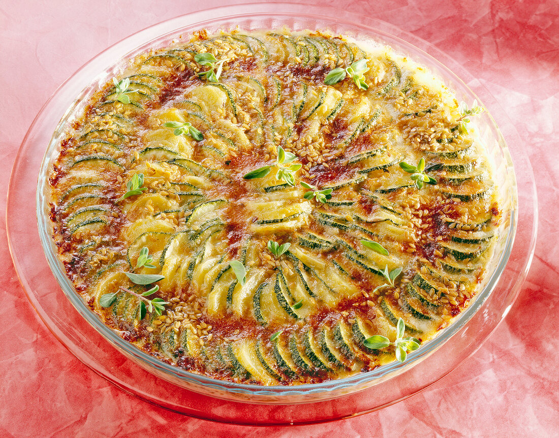 Potato and zucchini gratin with linseed in serving dish