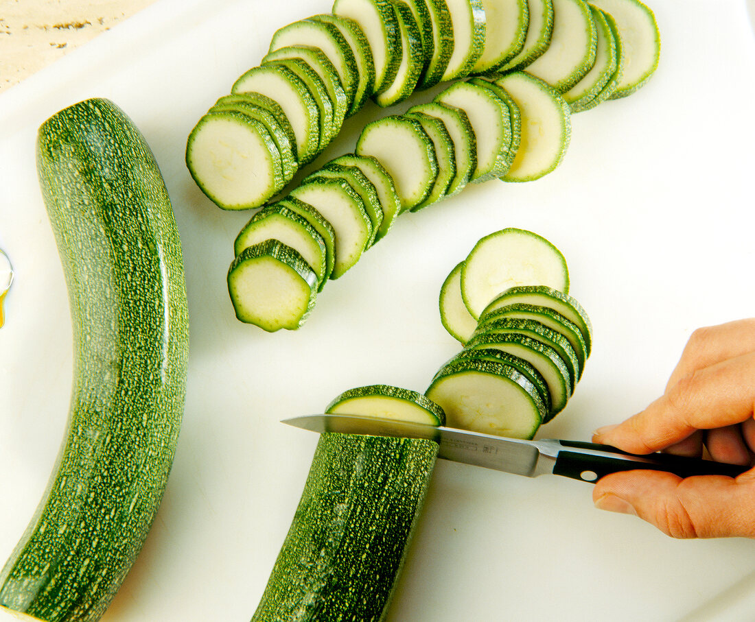Close-up of zucchini being cut into slices