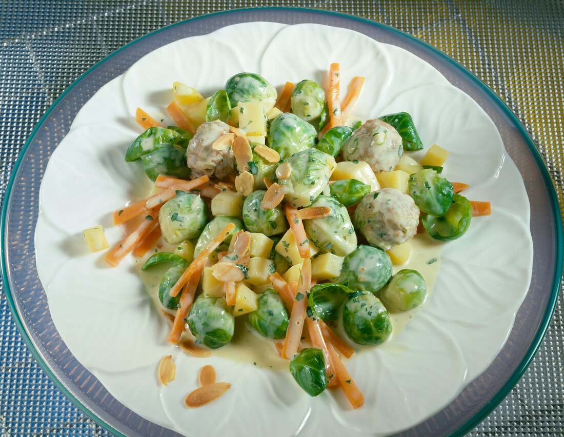 Brussels sprouts with meatballs, carrots, potatoes and parsley on plate