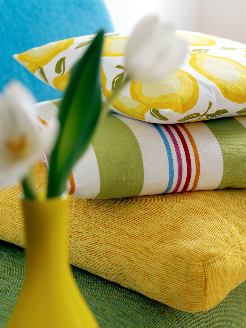 Close-up flower vase with three different types of stacked pillows