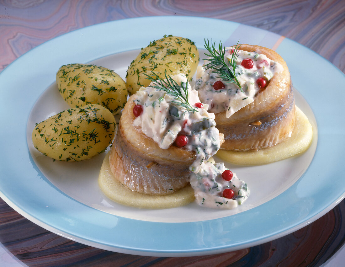 Matjes fillets with apples, cranberries and potatoes on plate