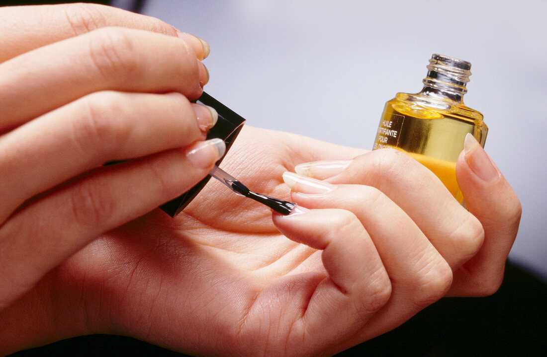 Close-up of woman wearing nail oil on her finger nails