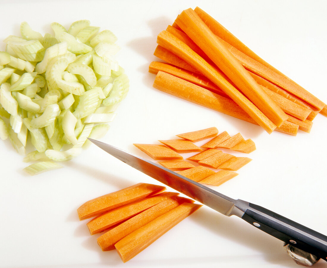 Celery and carrot being sliced to prepare oxtail ragout