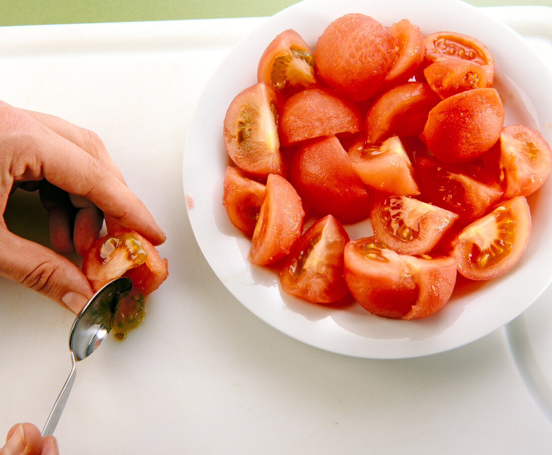 Step 1 zu Gemüse-Omelett - Kerne aus Tomaten mit Teelöffel entfernen