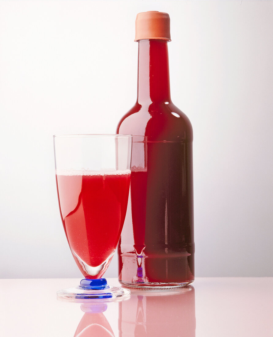 Kirsch-Himbeer-Saft in Flasche und Glas.