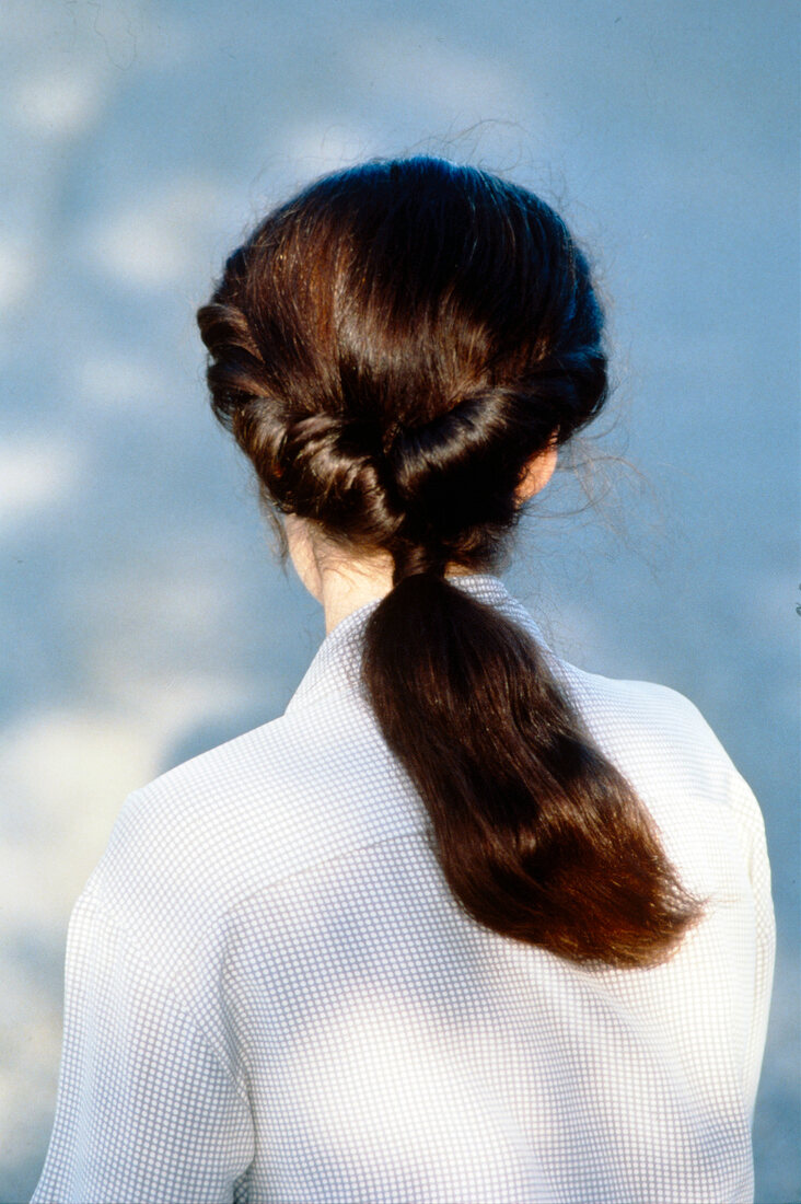 Rear view of brunette woman with ponytail and side rolled hair